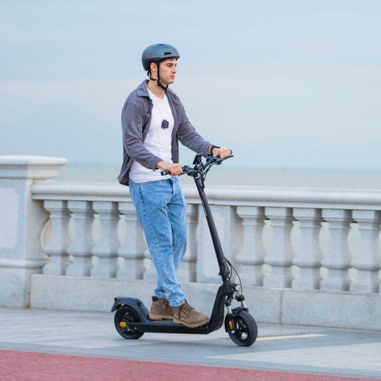 Man riding the Joyor C10-E ABE electric scooter beside the beach