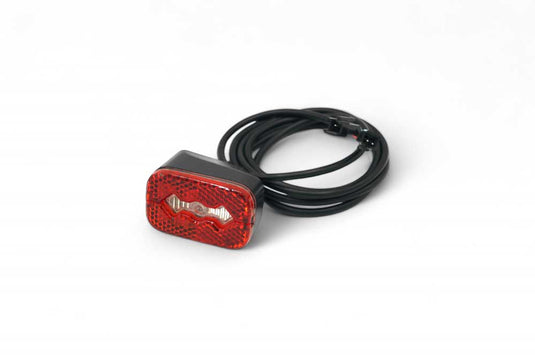 Red rear light for electric scooter with a black cable.